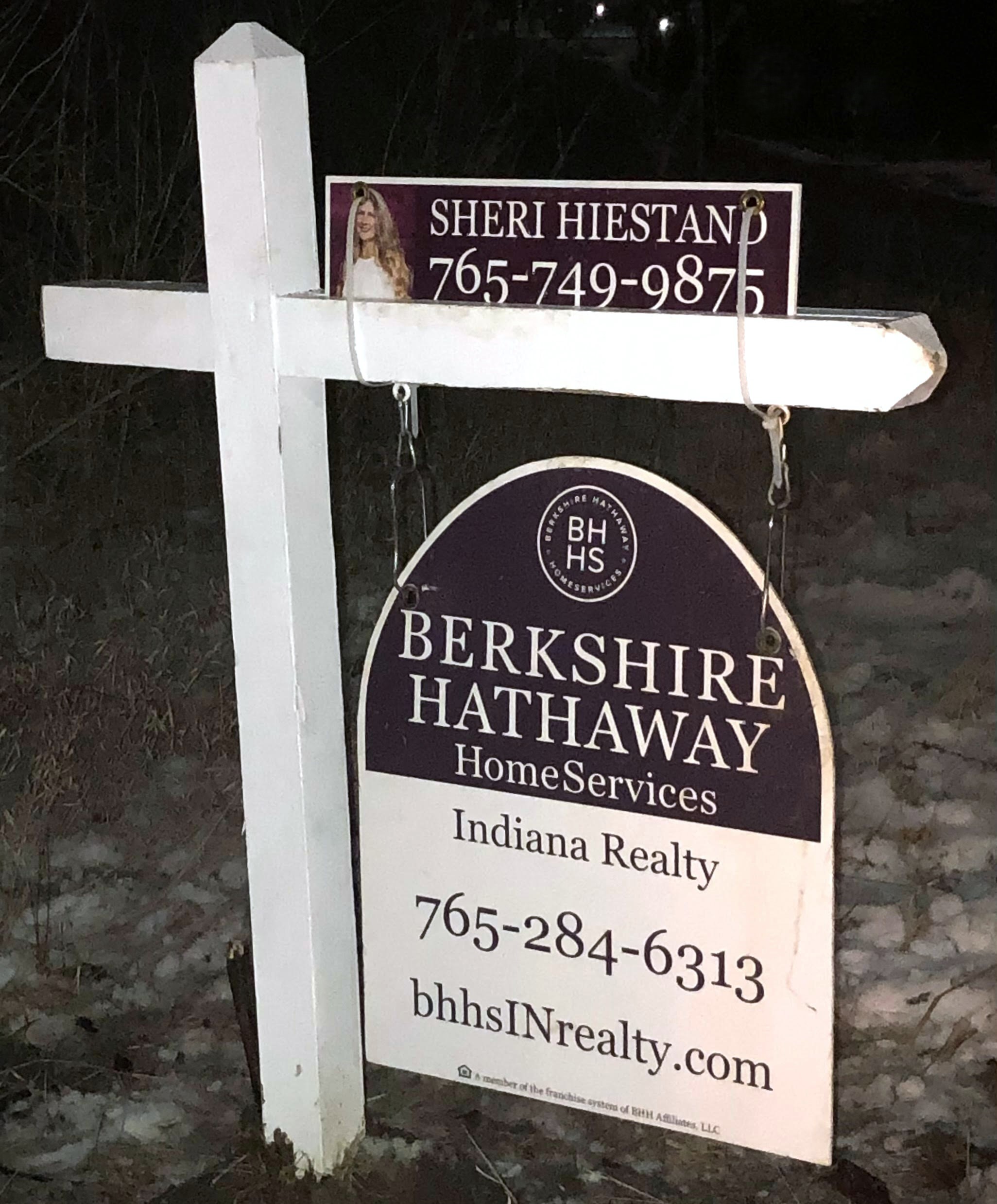 A sales sign in front of a home with Sheri's contact information